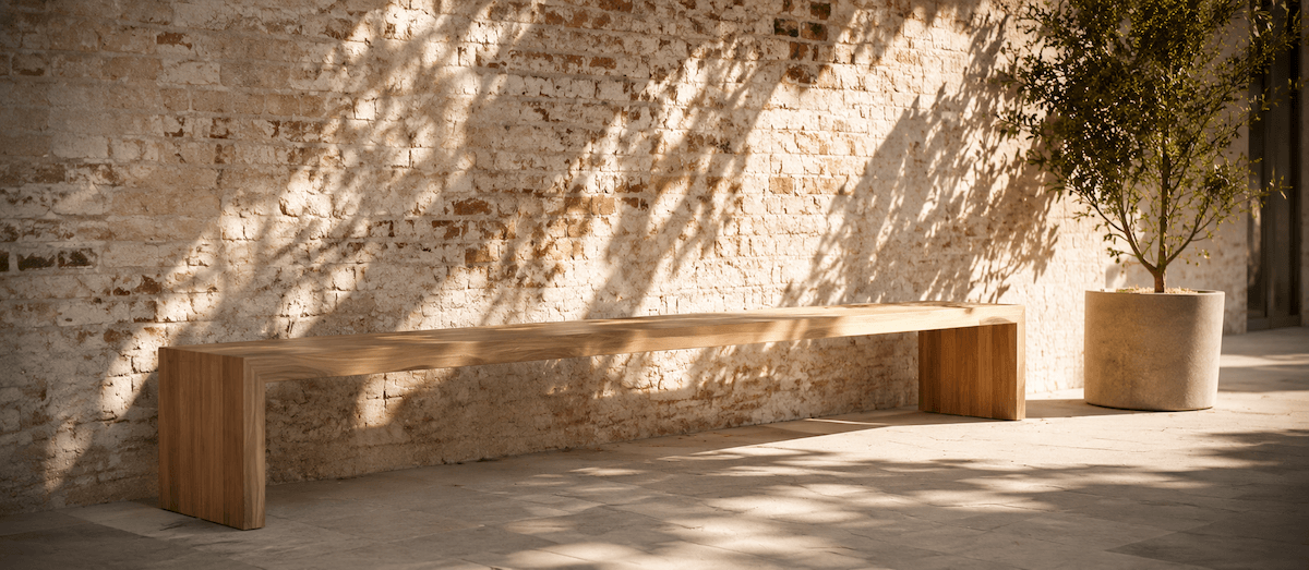 Holzbank vor Backsteinmauer im Schatten eines Baums (KI-generiert)