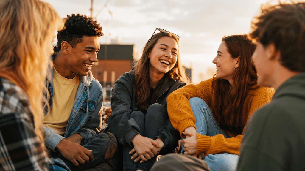 Internationale Jugendliche lachen zusammen — „seine Menschen“ finden durchbricht die Einsamkeit (KI-generiert)