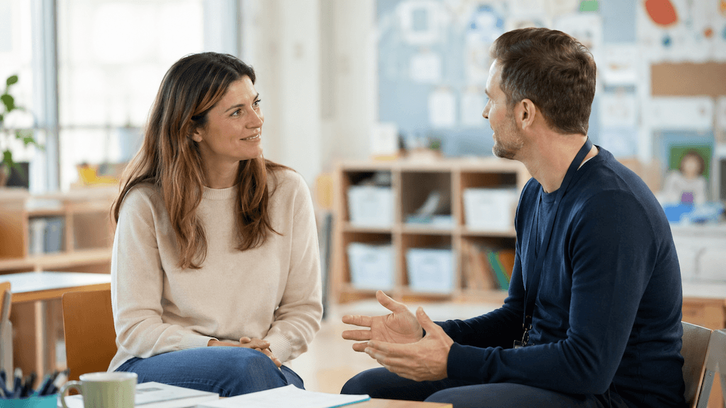 Elternteil und Lehrkraft im ruhigen Gespräch im Klassenzimmer — abgestimmte, druckfreie Haltung von Schule und Elternhaus (KI-generiert) (KI-generiert)